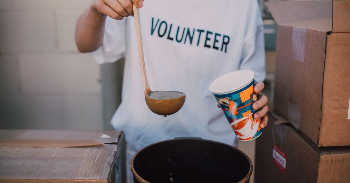 A volunteer serving a hot meal