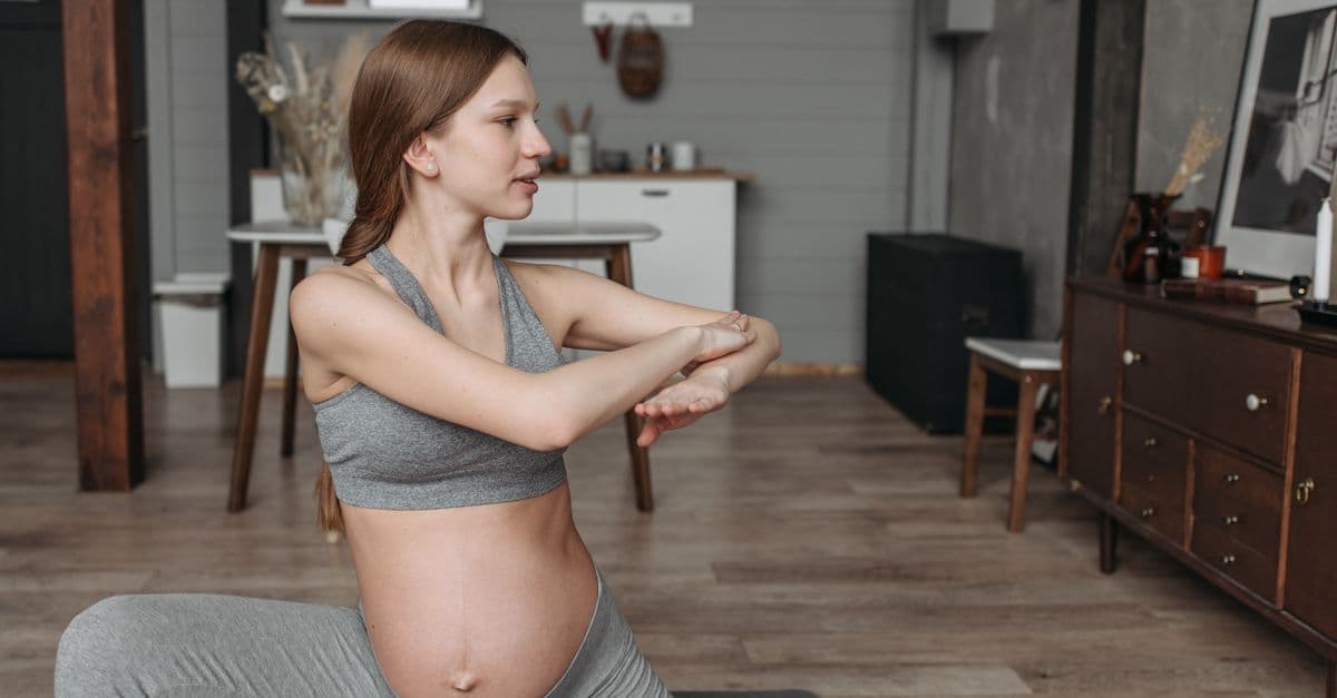 A pregnant woman doing gentle exercise at home