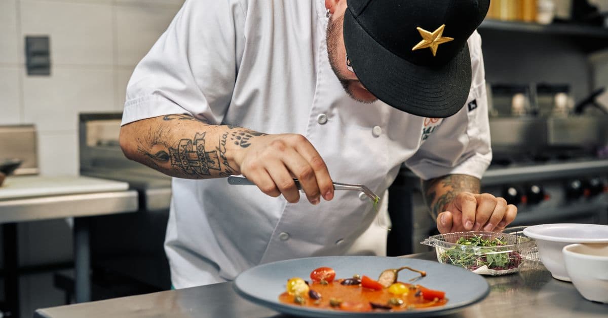 A chef plating fresh food in a restaurant kitchen