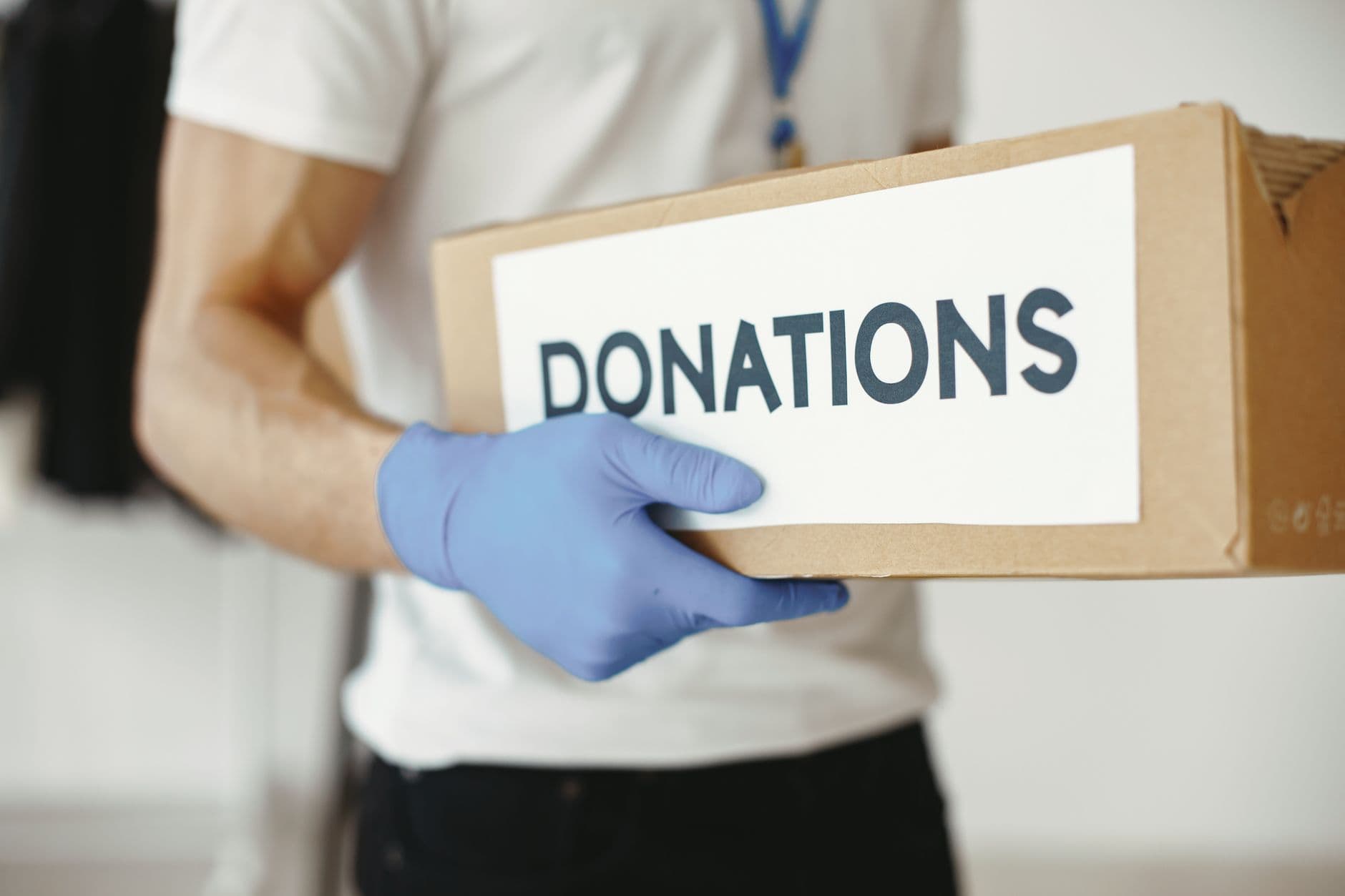 A volunteer carrying a box labeled Donations