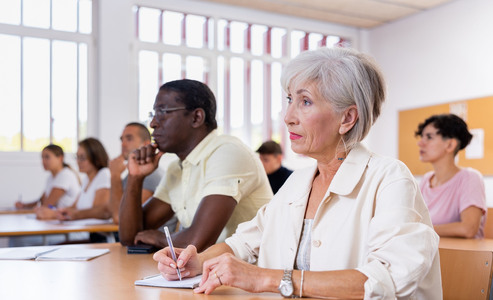 Mature woman with other different ages students in studying with their colleagues
